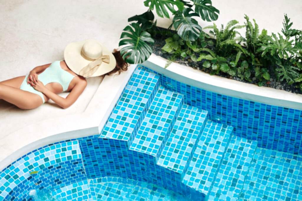 Woman sunbathing by a luxury pool
